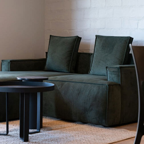 Modern dark green sofa set in contemporary living room with black coffee table.