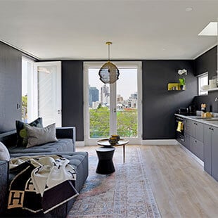 Stylish living room interior with large window overlooking city skyline in South Africa.