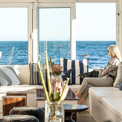 Coastal lounge with ocean view and comfortable seating in a seaside apartment in South Africa.