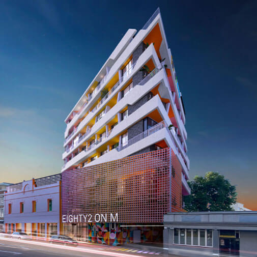 Modern multi-storey residential building with vibrant design and balconies in an urban setting.